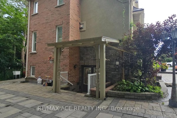Entrance to the basement with a wooden pergola and stone accents. - Bsmt - 25 Fawnridge Trail, Toronto