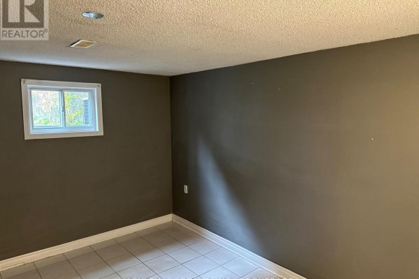Empty room with a small window and dark gray walls. - Bsmt - 2546 Palisander Avenue, Mississauga