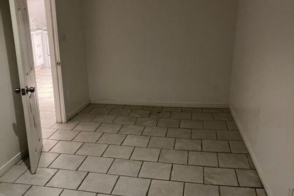 Unfinished basement room with white walls, grey tiled floor, and open doorway. - Bsmt - 2849 Dufferin Street, Toronto
