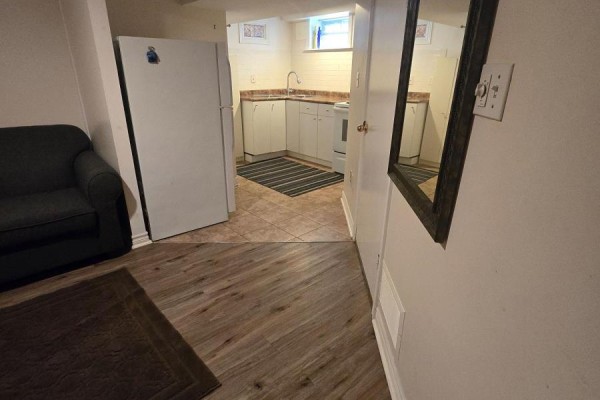 Interior view of the basement with a living area, kitchen access, and laminate flooring. - Bsmt - 285 Fiona Terrace, Mississauga