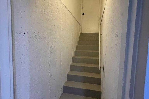 Concrete stairs leading down into a basement with white walls and a metal handrail. - Bsmt - 304 Russet Way, Vaughan