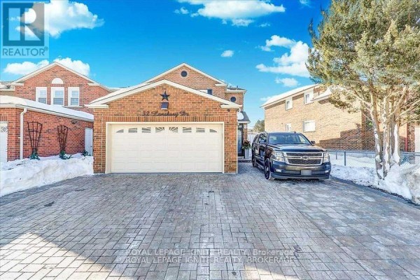 A wide view of the front exterior of a brick house with a paved driveway and snow. - Bsmt - 32 Lansbury Drive, Toronto