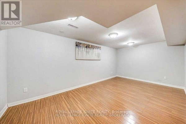 Unfinished basement room with wood laminate flooring, white walls, and recessed lighting. - Bsmt - 32 Lansbury Drive, Toronto