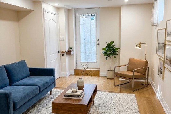 Cozy living area with blue sofa, wooden coffee table, and large window - Bsmt - 4029 Powderhorn Court, Mississauga