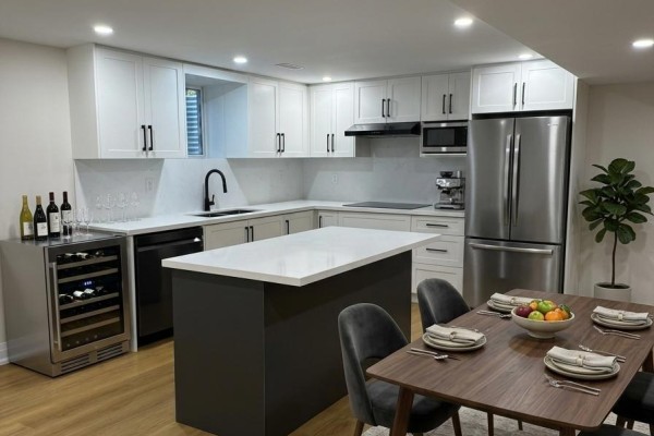 Modern kitchen with white cabinets, island, stainless steel appliances, and dining area - Bsmt - 4029 Powderhorn Court, Mississauga