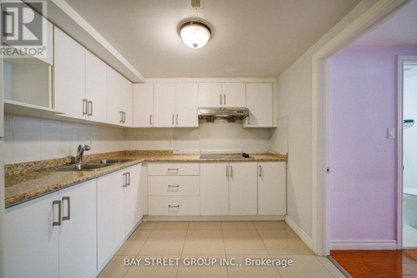 Close-up of kitchen area featuring white cabinets and gas stove - Bsmt - 5 Lockdare Street, Toronto