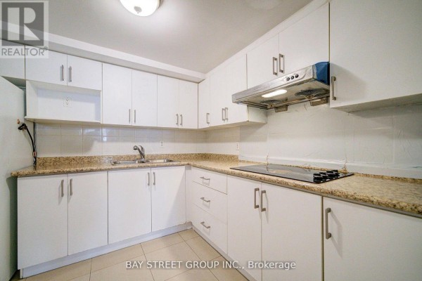 Open kitchen layout with refrigerator, table, and tiled flooring - Bsmt - 5 Lockdare Street, Toronto