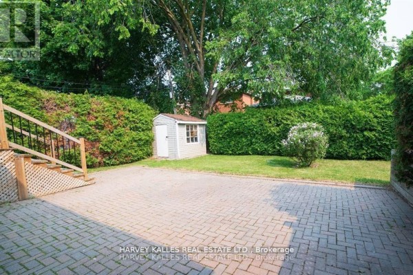 Backyard with a paved patio, a small garden shed, and mature hedges. - Bsmt - 550 Glencairn Avenue, Toronto