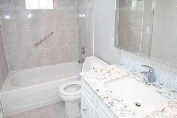 Basement bathroom with a bathtub, toilet, and vanity with a granite countertop. - Bsmt - 550 Glencairn Avenue, Toronto
