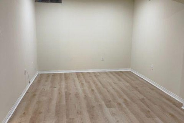 Empty room with light beige walls and light wood-look vinyl flooring. - Bsmt - 584 Doubletree Lane, Newmarket