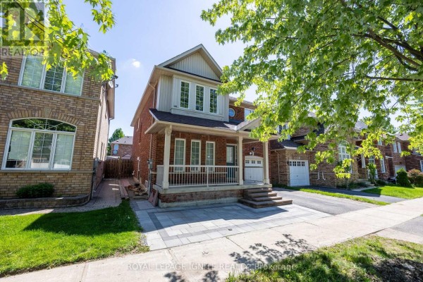 Side exterior view of a red brick house featuring a covered porch, garage, and green lawn. - Bsmt - 7 Vecchia Street, Markham