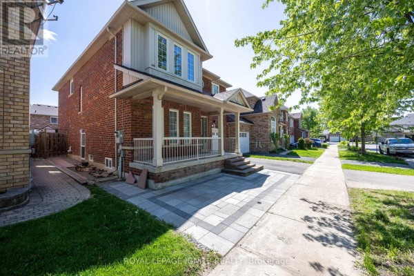 View of the house from the sidewalk, showing the red brick exterior, covered porch, and driveway. - Bsmt - 7 Vecchia Street, Markham