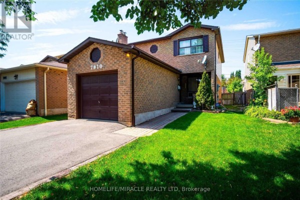 View of the house from the front lawn, showing the garage and entrance. - Bsmt - 7010 Cordingley Crescent, Mississauga