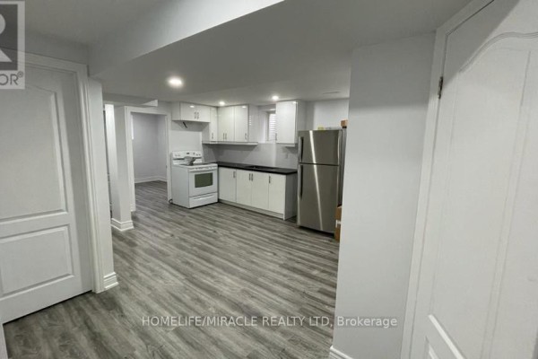 Basement with an open-concept layout showing the kitchen and hallway. - Bsmt - 7010 Cordingley Crescent, Mississauga