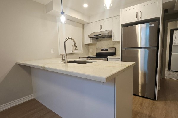 Kitchen island with sink and faucet, white cabinets, stainless steel refrigerator and stove. - Bsmt - 79 Mantz Crescent, Whitby