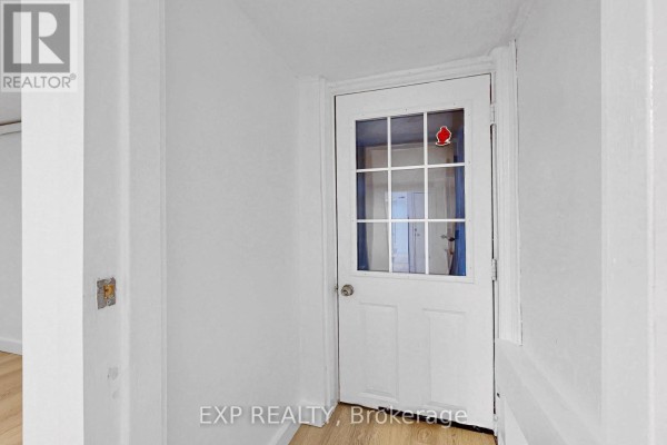 Open kitchen view with a refrigerator, stove, and access to the bathroom - Bsmt - 858 Manning Avenue, Toronto