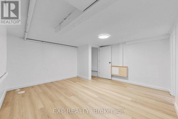 Bright room with a window, beige tile flooring, and a wooden door - Bsmt - 858 Manning Avenue, Toronto