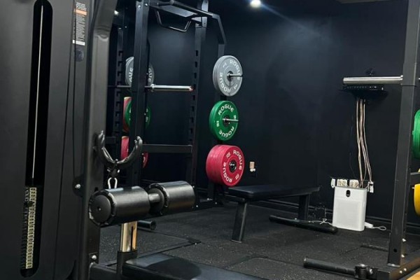 Close-up of weight plates on a rack and a weight bench in a gym. - Bsmt - 860 North Park Drive, Brampton