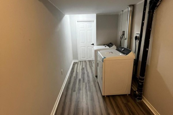 Laundry room with white washer and dryer, grey walls, and a white door. - Bsmt - 96 Honey Street, Cambridge