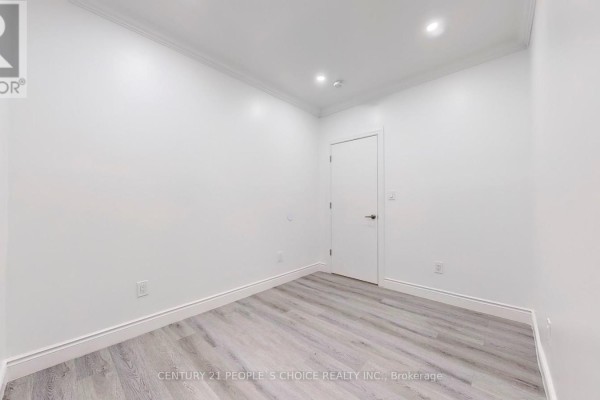 Empty bedroom with white walls, white trim, and light grey wood-look laminate flooring. - Bsmt 2 - 26 Lyle Way, Brampton