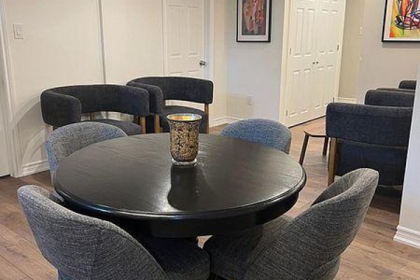 Dining area with black round table, grey upholstered chairs, and dark grey accent chairs. - Bsmt A - 10 Green Manor Crescent, Vaughan
