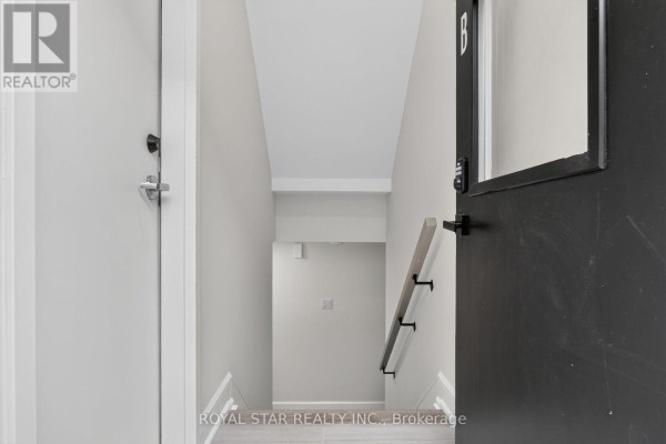 View looking down a narrow staircase with light wood steps and a black railing inside a residential building. - Bsmt #b - 522 Mutual Street, Ottawa