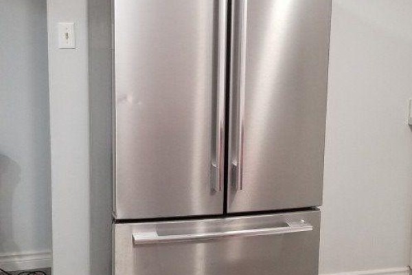 A stainless steel French door refrigerator with a bottom freezer drawer in a room with grey walls. - Bsmt Rm - 12 Flerimac Road, Toronto
