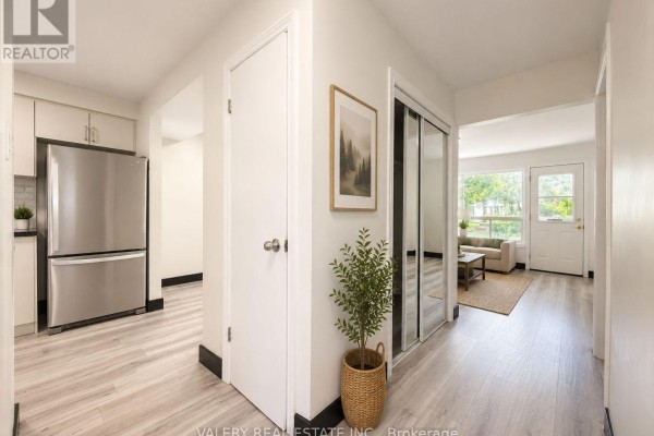 Hallway with light wood laminate flooring, white doors, and mirrored closet doors. - C - 532 Sunnydale Place, Waterloo