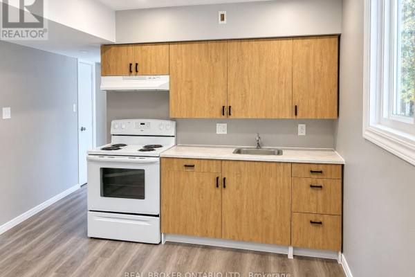 Compact kitchen with light wood laminate cabinets, white appliances, and light grey countertops. - C - 93 Brybeck Crescent, Kitchener
