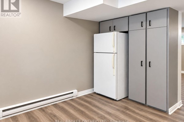 Kitchen area with a white refrigerator next to grey floor-to-ceiling cabinets. - C - 93 Brybeck Crescent, Kitchener