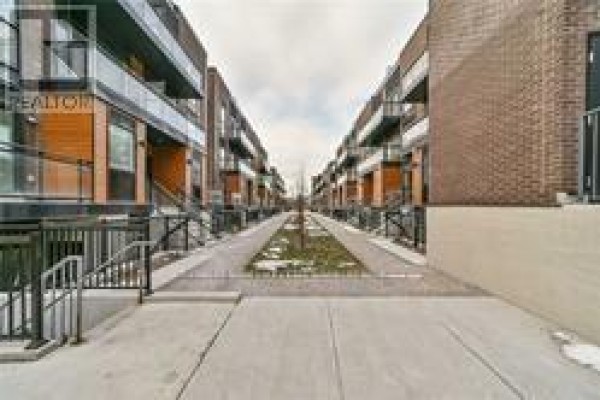 View down a pedestrian walkway between rows of townhouses. - C-302 - 5299 Highway 7 Street, Vaughan
