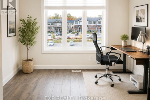 Living area with a brown leather sofa, television, small dining table, and a stainless steel refrigerator. - C14 - 160 Rochefort Street, Kitchener