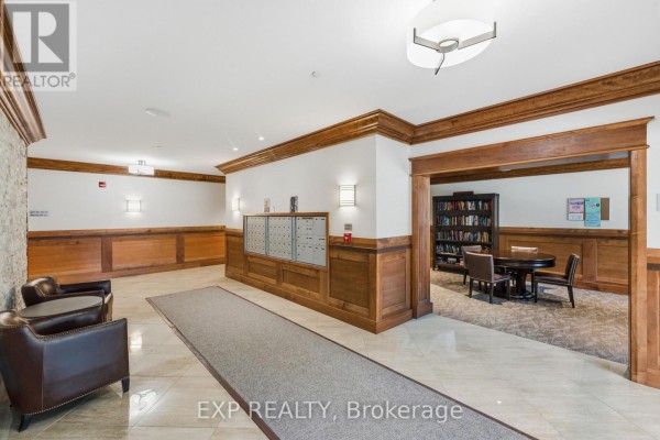 Another view of the lobby with reading area, mailboxes, and decorative wood paneling. - C301 - 258 Coleman Street, Carleton Place
