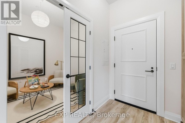 Entrance area with a glass door, modern decor, and a small seating area. - C301 - 258 Coleman Street, Carleton Place