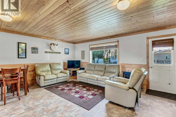 Living room featuring leather sofas, wood paneling, and a decorative fireplace. - C47 Forty Mile Park, Rural Forty Mile No  8, County Of