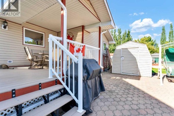 Kitchen equipped with wooden cabinets, white appliances, and dual sinks, with a view of the living area. - C47 Forty Mile Park, Rural Forty Mile No  8, County Of