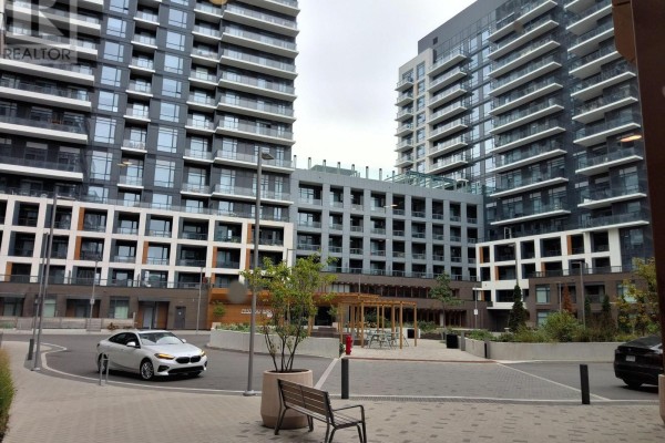 Street view of apartment buildings with a courtyard and seating area. - C701 - 8 Beverley Glen Boulevard, Vaughan
