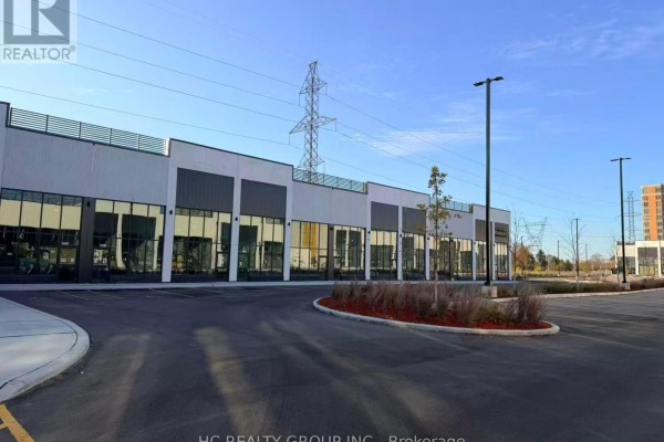 Exterior view of a commercial strip mall with multiple units and a parking lot. - C8 - 3101 Kennedy Road, Toronto