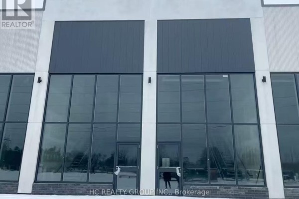 Close-up of a commercial building facade with large windows and double doors. - C8 - 3101 Kennedy Road, Toronto
