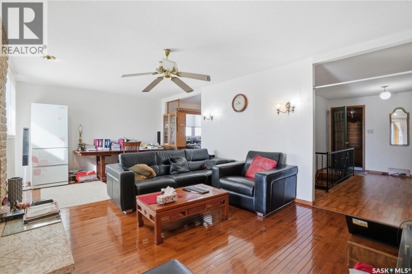 Living room with black leather sofas, hardwood floors, and ceiling fan. - Chamberlain Acreage 3, Chamberlain