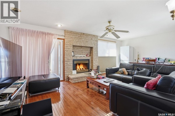 Living room with stone fireplace, large television, and sliding glass doors. - Chamberlain Acreage 3, Chamberlain