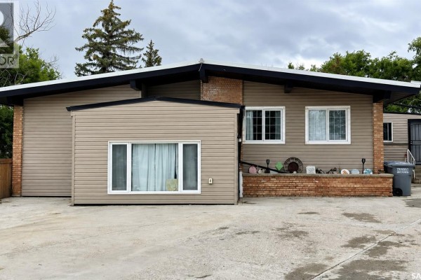 Front exterior of a tan-sided house with brick accents and white-framed windows. - Chaplin Acreage - Two Houses And Large Shop, Chaplin
