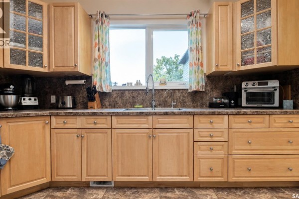 Kitchen with light wood cabinets, granite countertops, and a double sink below a window. - Chaplin Acreage - Two Houses And Large Shop, Chaplin