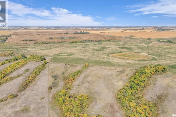 Aerial view of rolling, treed hills extending into a large, flat agricultural landscape. - Craven Valley Acres, Longlaketon Rm No  219
