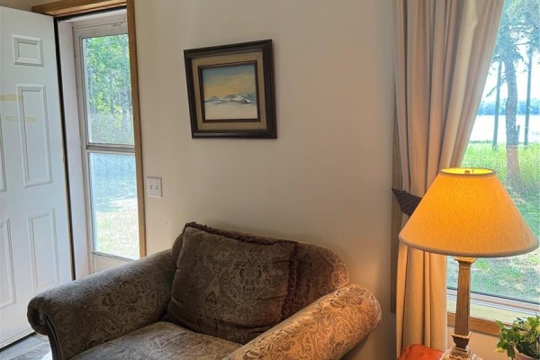 Bedroom with a floral comforter and a wicker dresser next to a window. - Crystal Lake Jewel, Crystal Lake