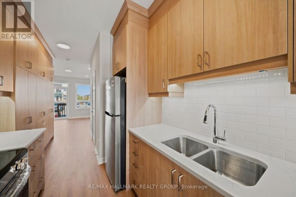 Kitchen with light wood cabinets, white quartz countertops, and stainless steel appliances. - D - 142 Conservancy Drive, Ottawa