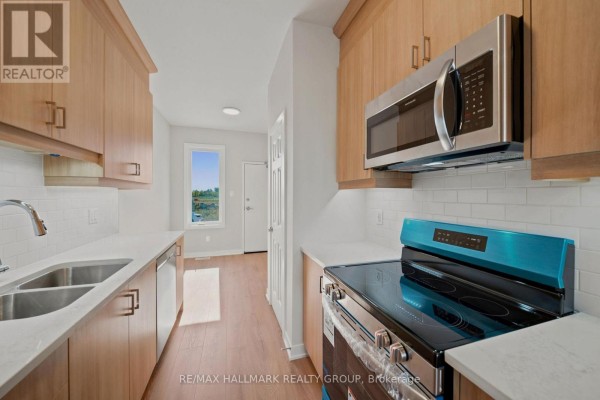 Kitchen with light wood cabinets, white subway tile backsplash, and stainless steel appliances. - D - 142 Conservancy Drive, Ottawa