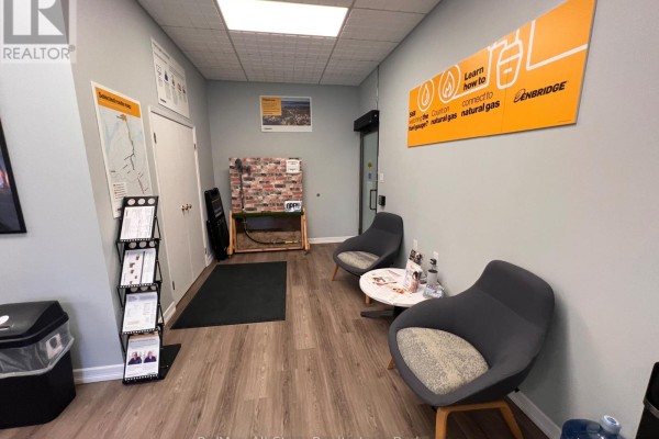 Waiting area with two dark grey chairs, a small table, and informational displays. - D - 71 Bolton Street, Kawartha Lakes