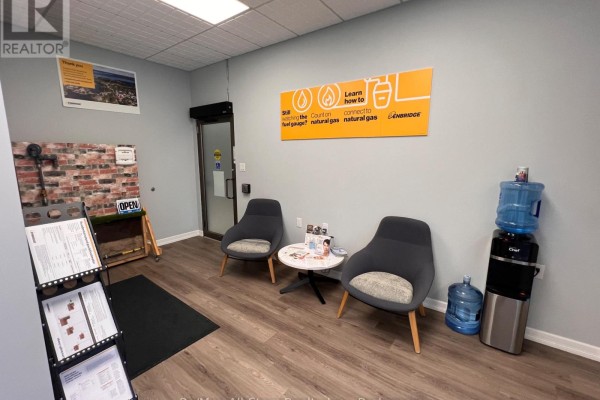 Reception area with two chairs, a water cooler, and an orange informational poster on the wall. - D - 71 Bolton Street, Kawartha Lakes