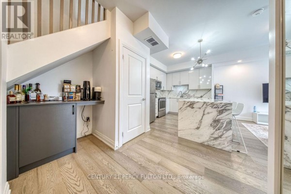 Hallway with wet bar and stairs leading up to an open-concept kitchen. - D-803 - 5289 Highway 7, Vaughan